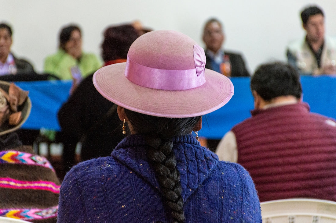 a woman wearing a pink hat in front of a group of people