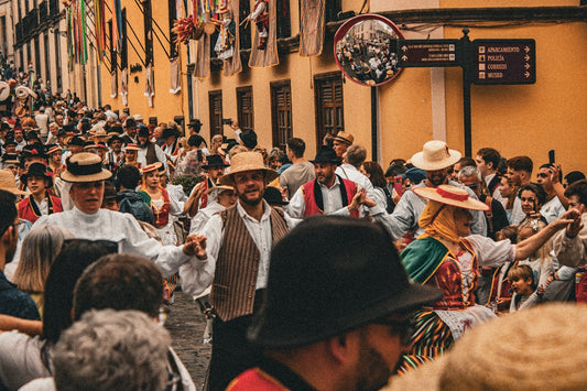 A crowd of people walking down a street next to tall buildings